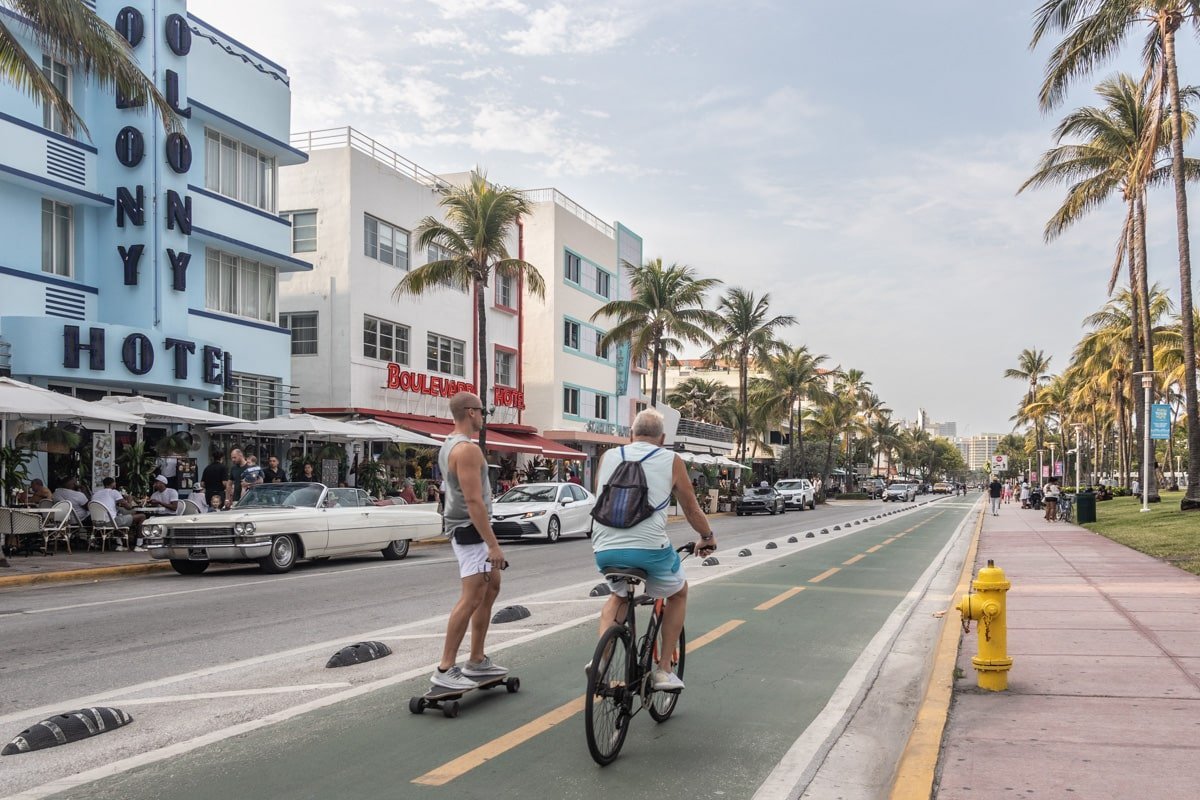 Cycliste et homme sur un skate sur l'avenue Ocean Drive