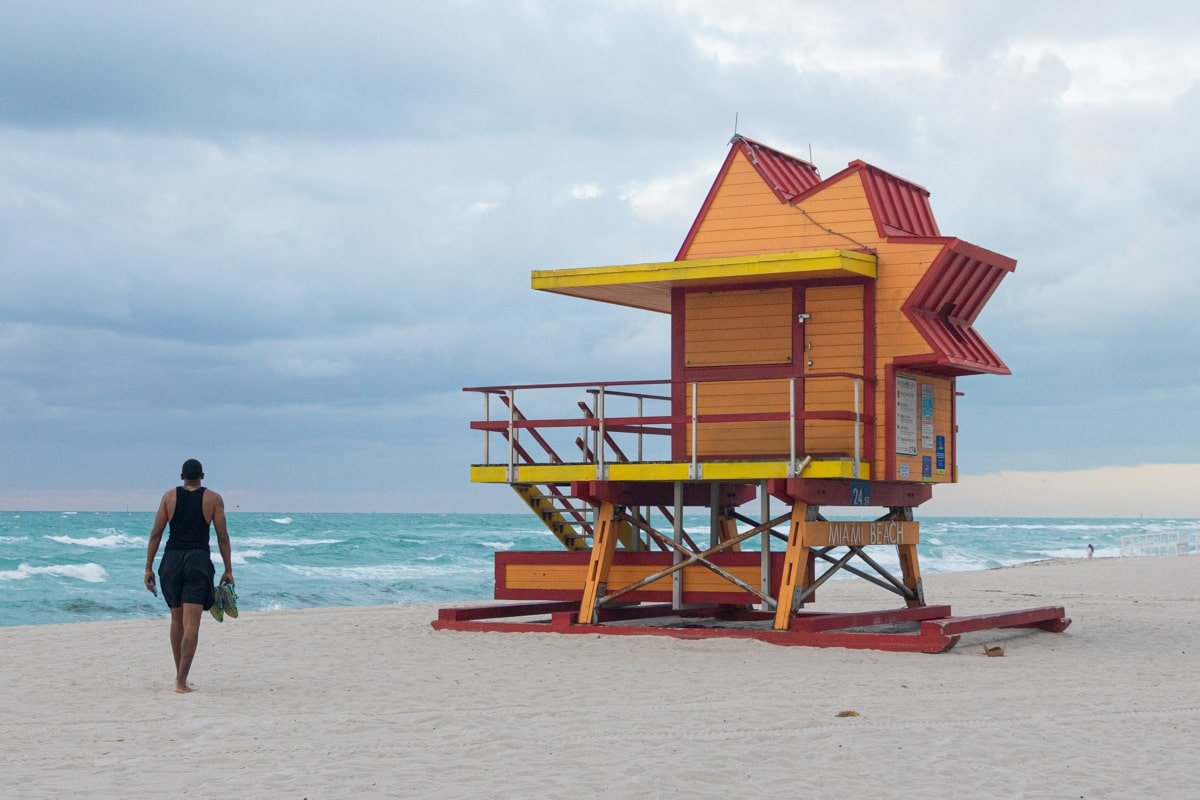Personne qui marche vers une cabane orange de South Beach