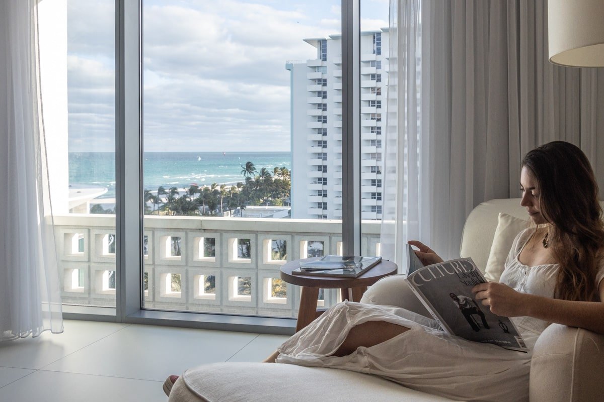 Personne assise en train de lire dans sa chambre au Miami Beach Edition