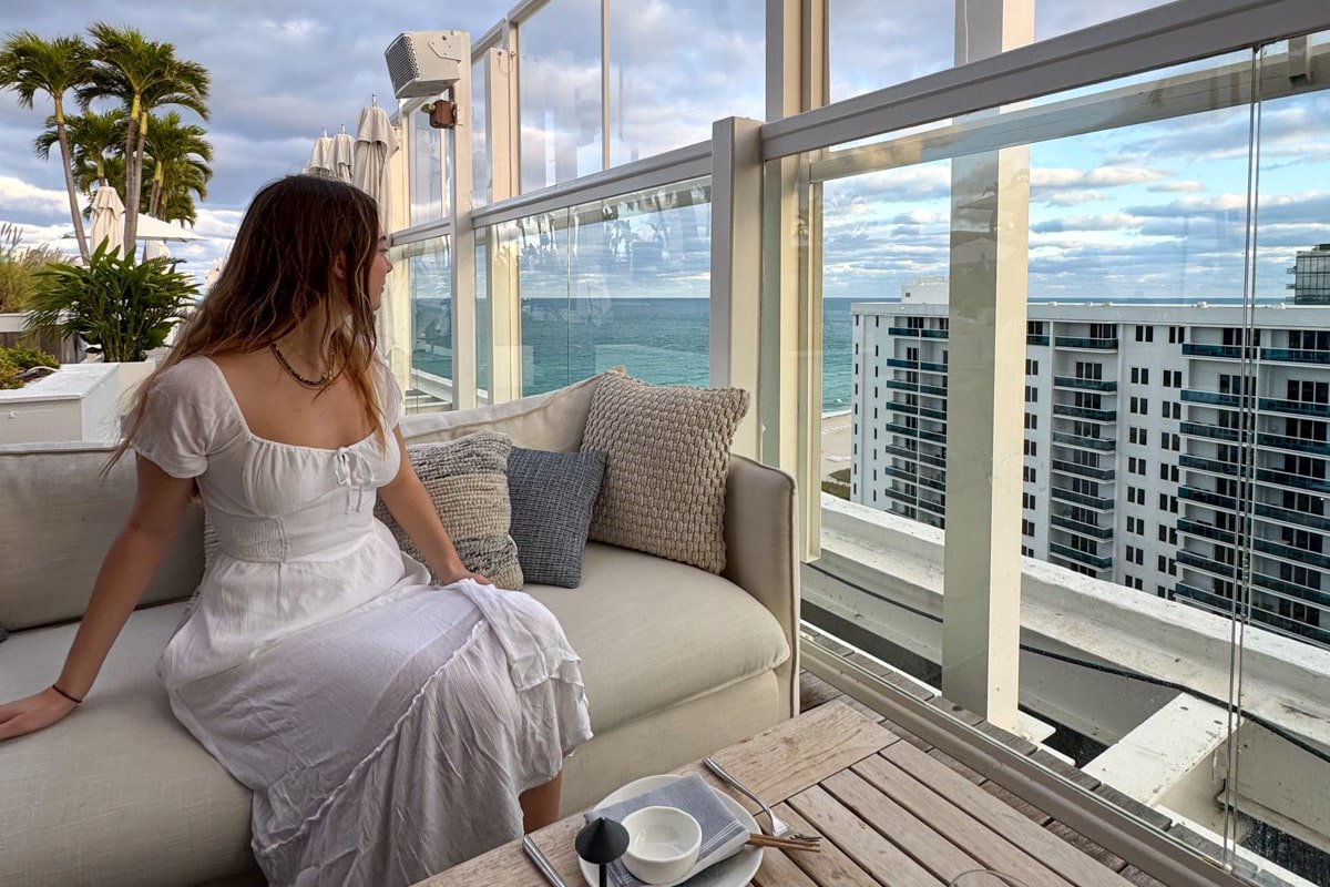 Femme assise observant l'océan depuis le rooftop du 1 Hotel