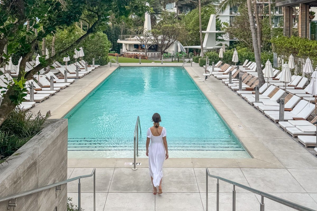 Femme qui marche à côté d'une piscine dans un bel hôtel