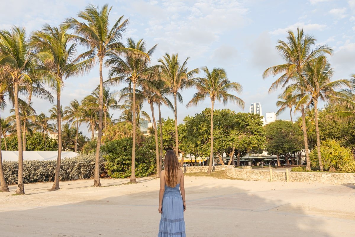 Femme qui marche à Miami Beach dans une allée avec des palmiers