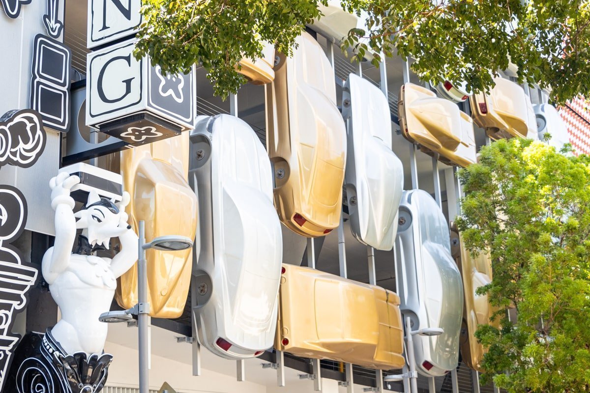 Art de rue avec des voitures blanches et dorées sur une façade