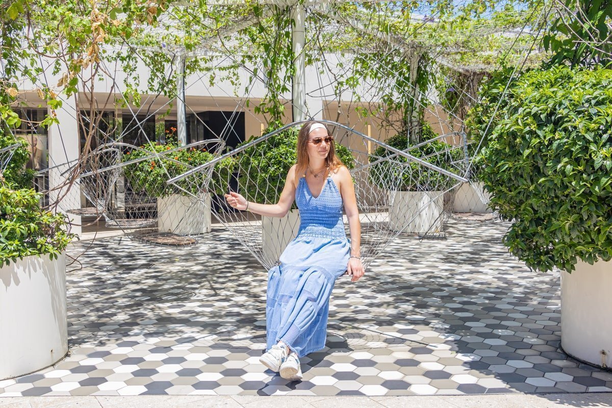 Personne assise sur un hamac dans un jardin