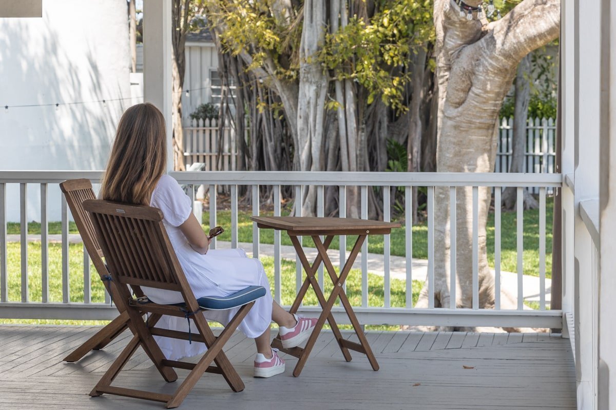 Femme assise dans le jardin, près d'une petite table