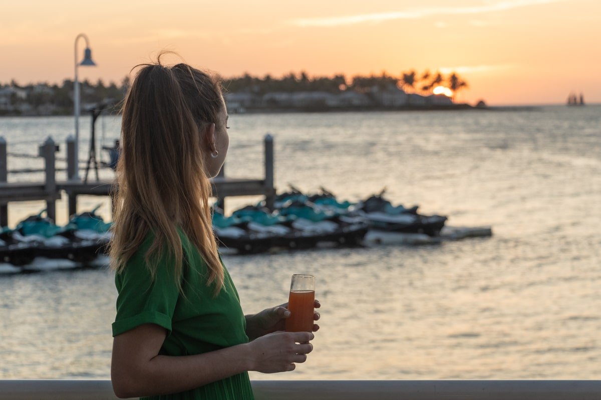 Femme devant un coucher de soleil à Key West, un verre à la main