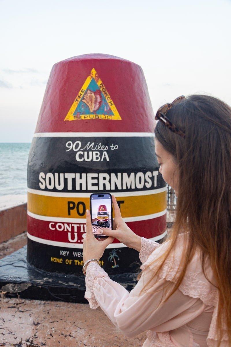 Femme qui prend en photo le monument coloré rouge, noir et jaune