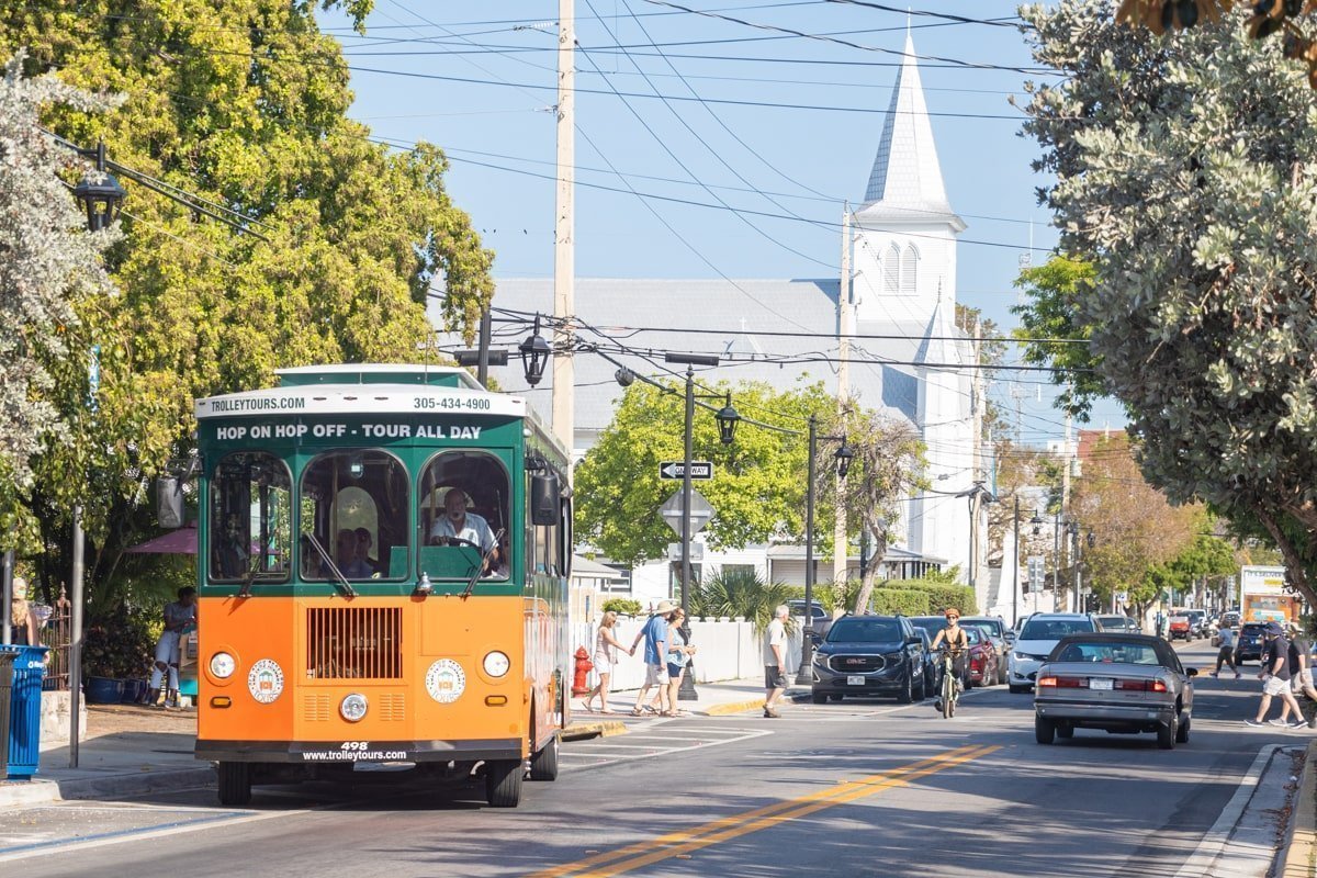 Trolley orange et vert dans la rue avec une église au fond