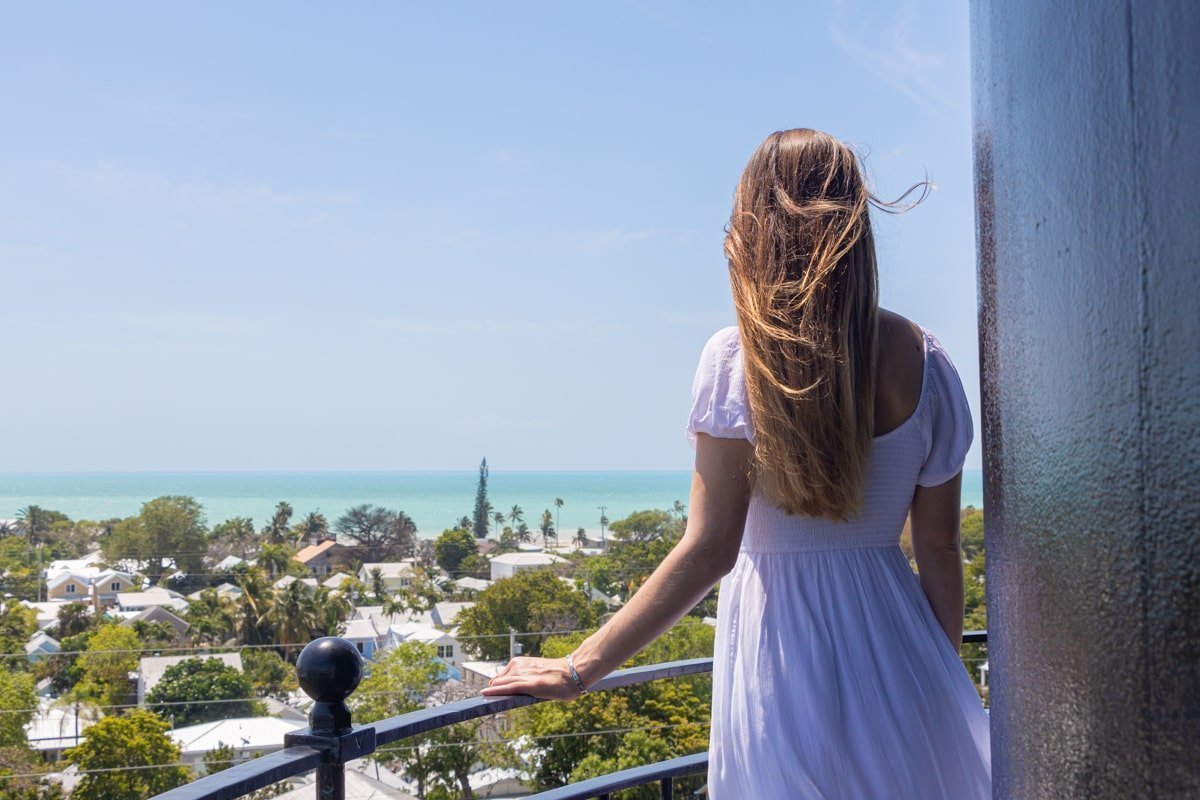 Femme qui contemple l'horizon depuis le sommet du phare