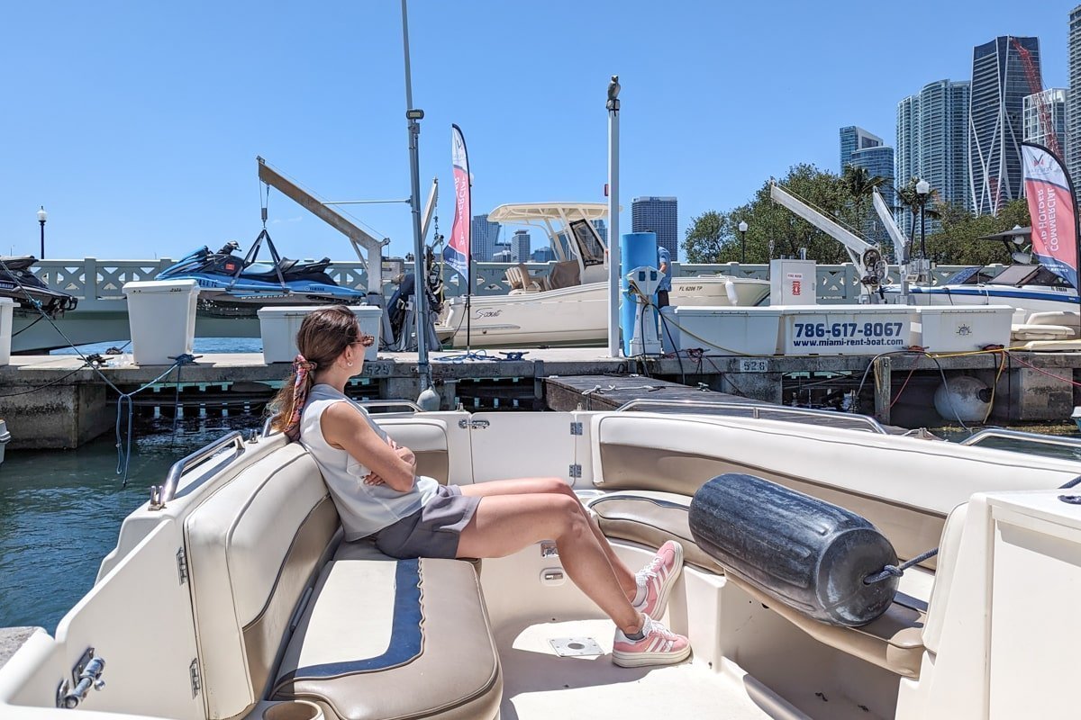 Femme assise dans un bateau amarré dans la marina