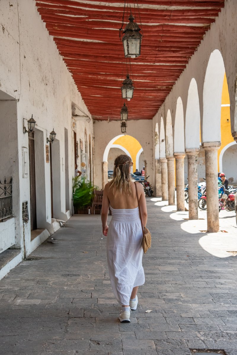 Personne qui marche dans une ruelle avec des arches